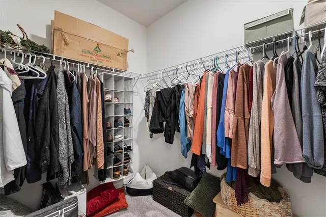 a view of walk in closet with clothes and shoes