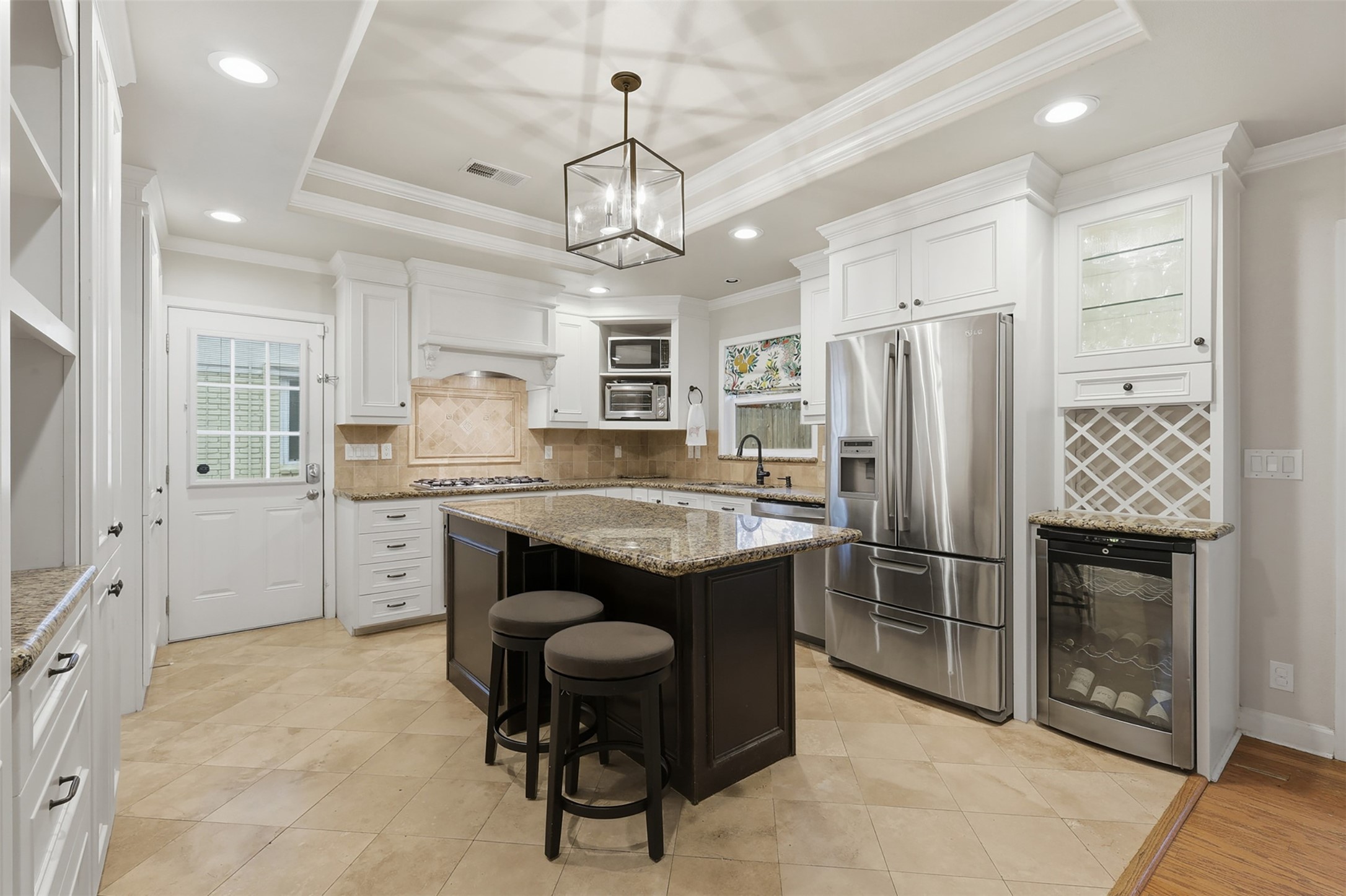 6236 Locke Lane Houston, TX 77057 - Photo 6 of 35 A chef's dream! This kitchen has tray ceilings and plenty of countertop space to prep meals. The door on the left leads to the driveway and the sink is situated under a window that faces the backyard.