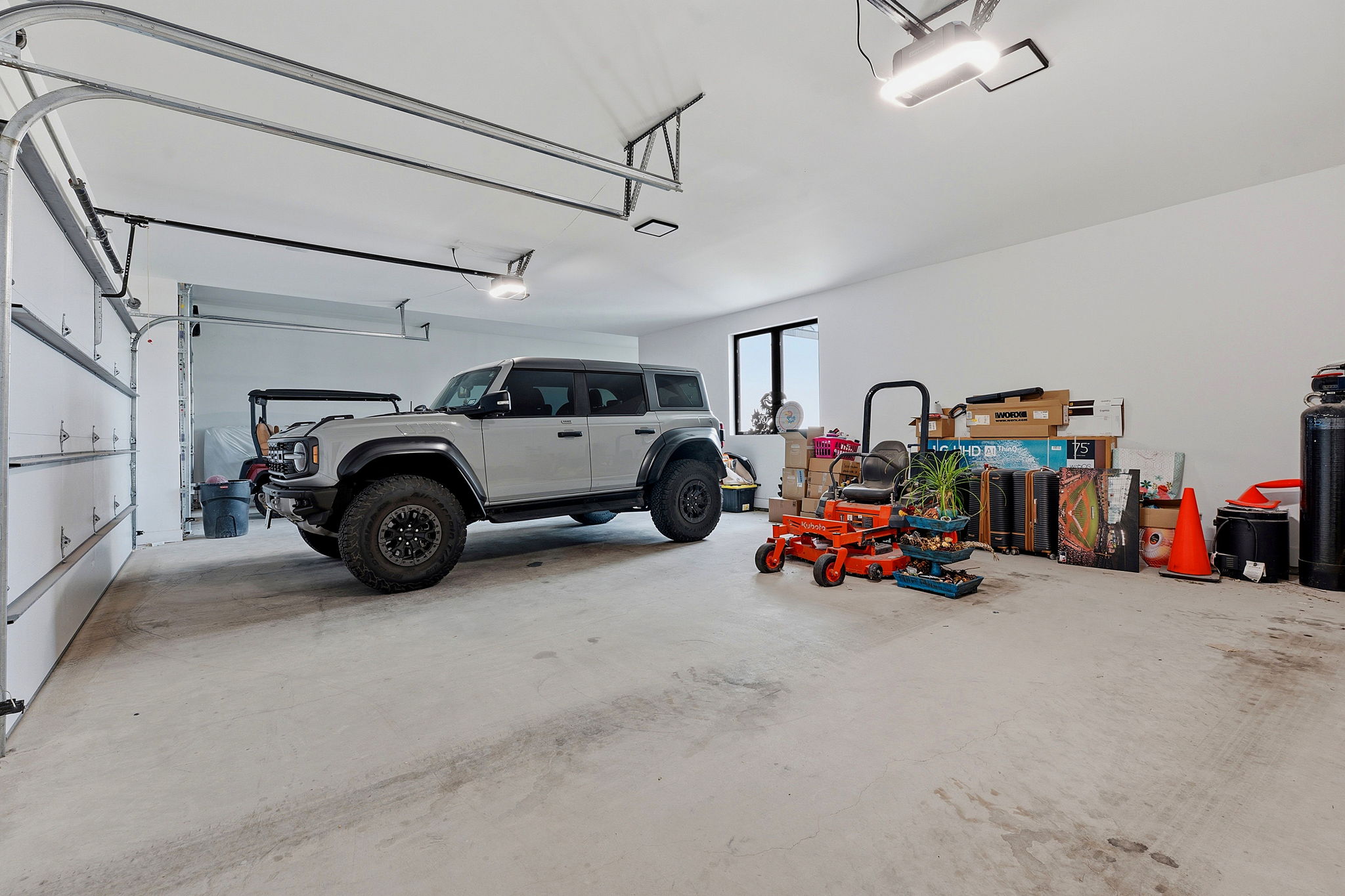 194 Placid Way Spring Branch, TX 78070 - Photo 27 of 37 Spacious garage with multiple overhead doors, concrete flooring, and ample lighting fixtures
