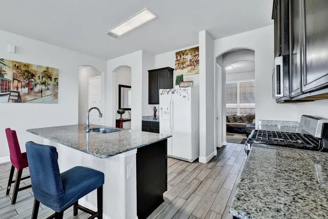 a kitchen with a table chairs refrigerator and microwave