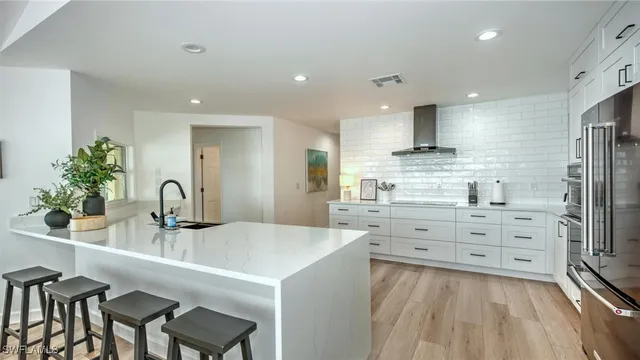 a kitchen with stainless steel appliances kitchen island granite countertop a sink and refrigerator