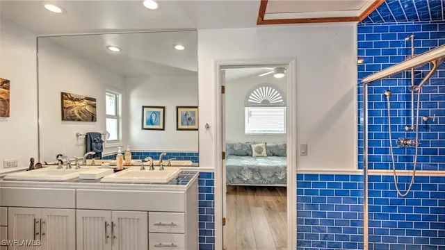a spacious bathroom with a double vanity sink a mirror and shower