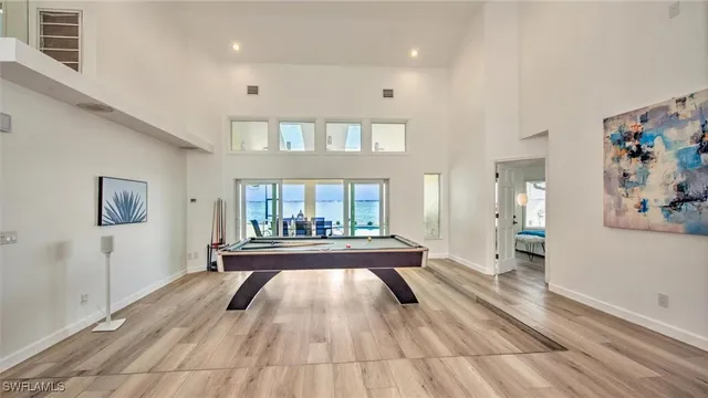 a room with pool table and windows