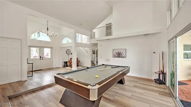 a living room with furniture large windows and wooden floor