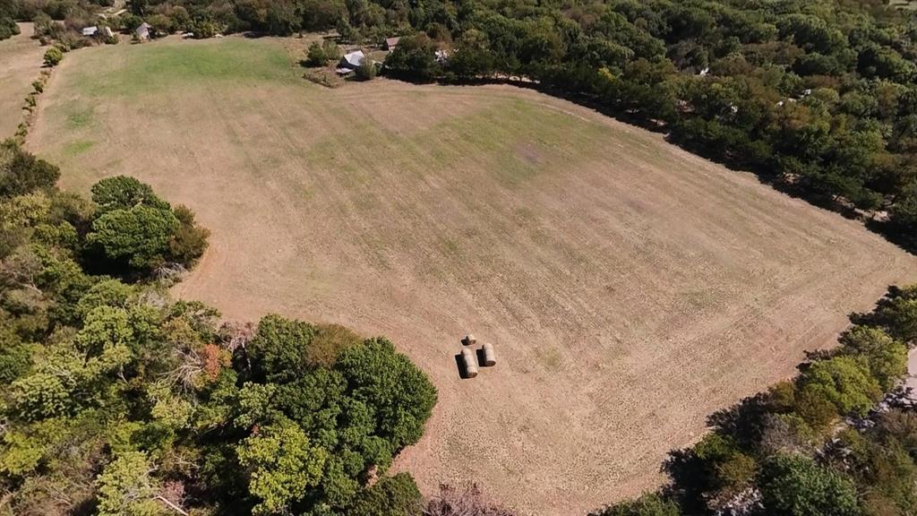 242 Oak Hill Road Van Alstyne, TX 75495 - Photo 9 of 10 Expansive cleared land featuring two hay bales and surrounded by mature trees