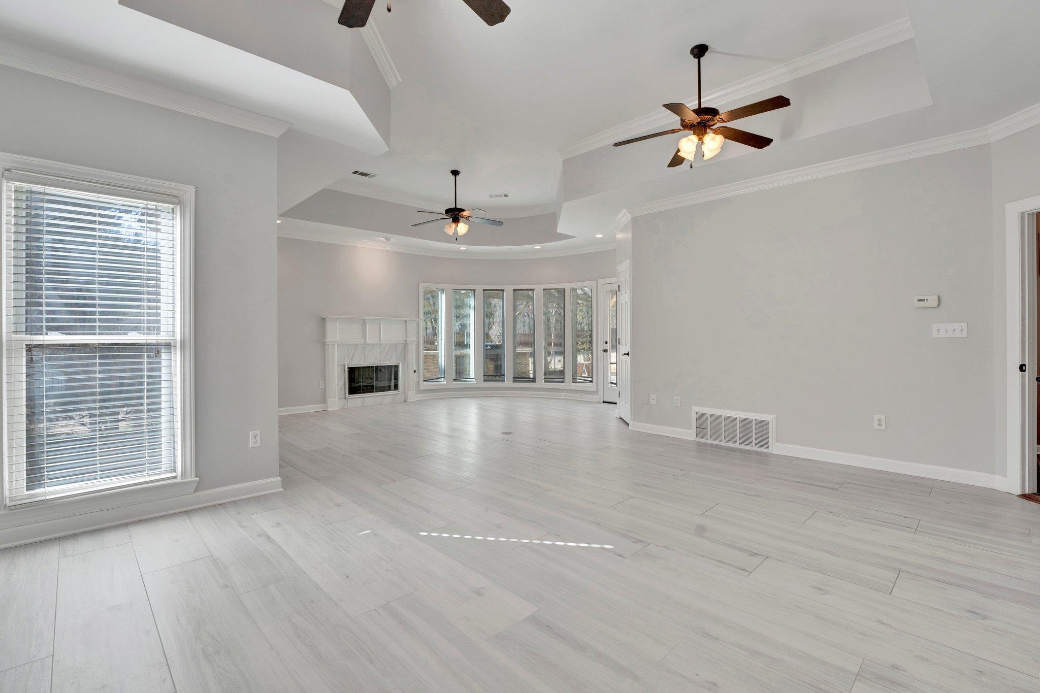 47 Summer Grove Road Memphis, TN 38018 - Photo 15 of 35 Unfurnished living room featuring visible vents, plenty of natural light, a tray ceiling, and a premium fireplace