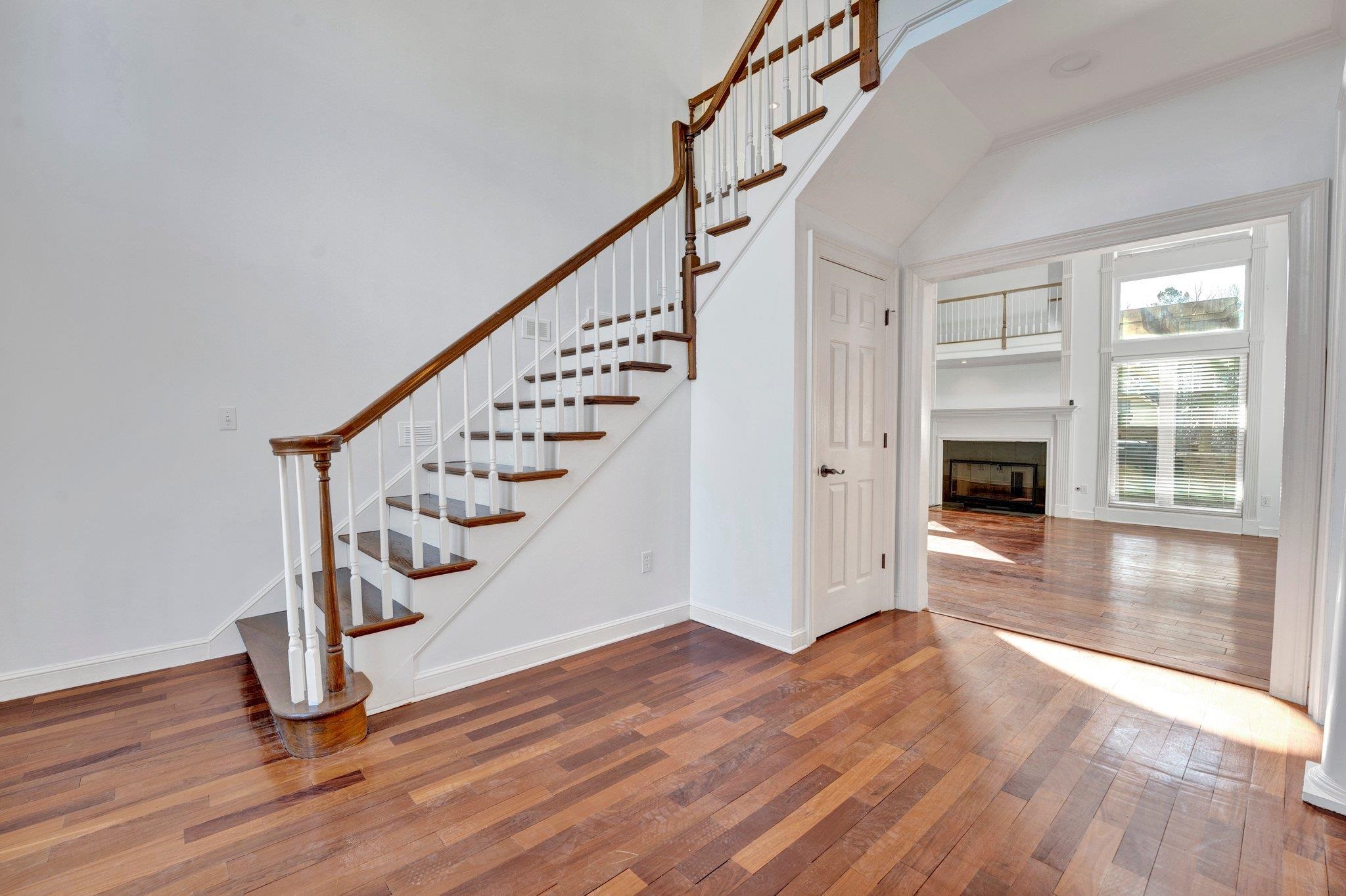 47 Summer Grove Road Memphis, TN 38018 - Photo 4 of 35 Staircase featuring baseboards, wood-type flooring, a high ceiling, and a fireplace