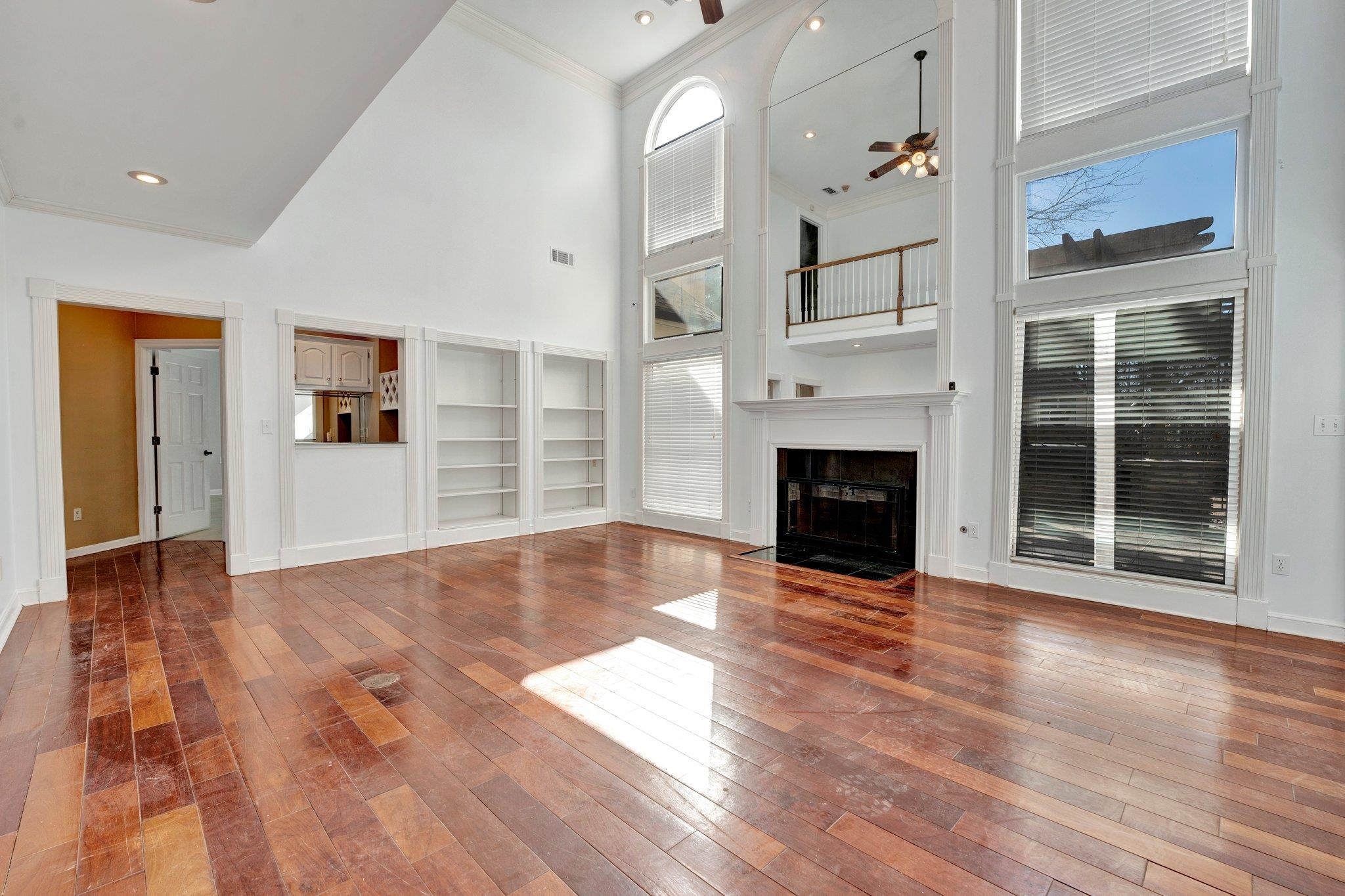 47 Summer Grove Road Memphis, TN 38018 - Photo 6 of 35 Unfurnished living room with a fireplace with flush hearth, ornamental molding, a ceiling fan, and wood-type flooring