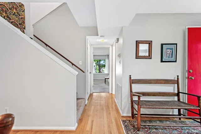a view of a hallway with wooden floor and staircase