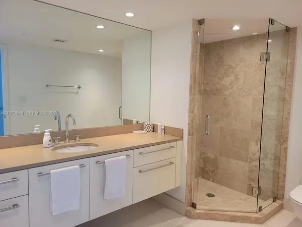 a bathroom with a shower sink and mirror