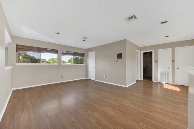 a view of a kitchen with wooden floor and electronic appliances