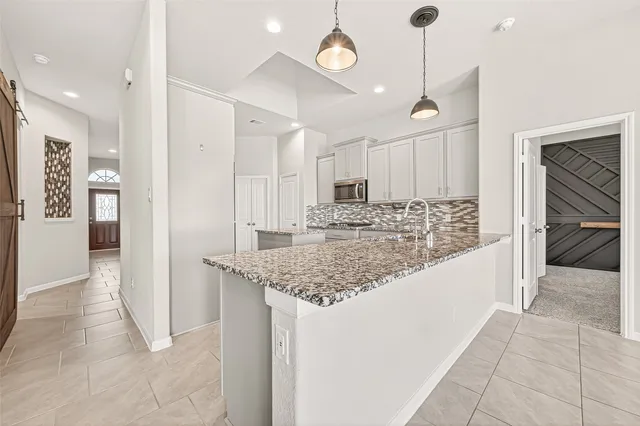a view of a house next to a big yard and large trees