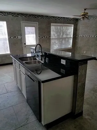 a kitchen with a sink and a stove top oven