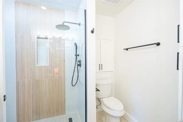 a bathroom with a toilet and a shower