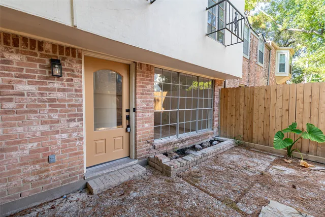 a backyard of a house with lawn chairs and iron fence