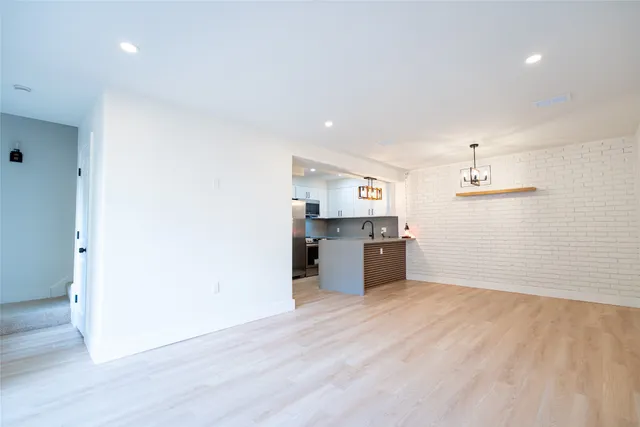 a large white kitchen with a sink and dishwasher