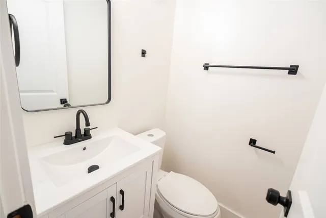 a bathroom with a sink a toilet and a mirror