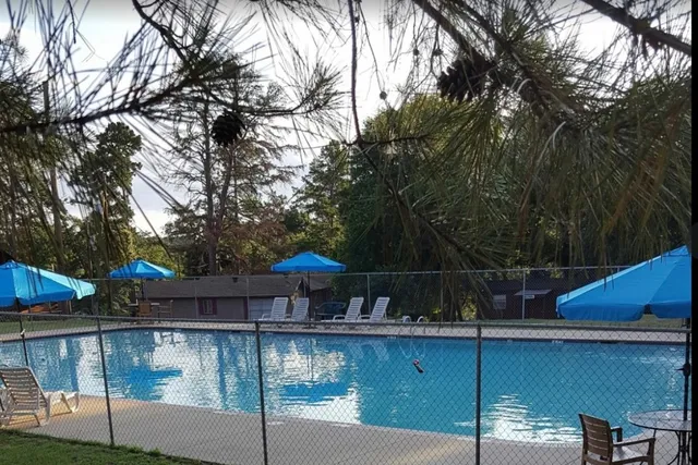 a view of swimming pool with table and chairs under an umbrella
