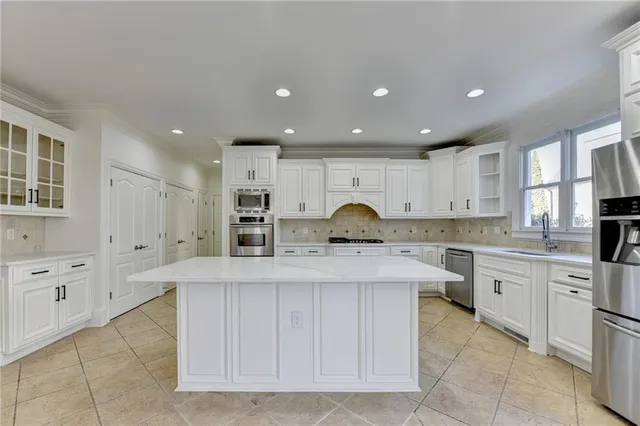 a kitchen with a refrigerator a stove top oven and a large window
