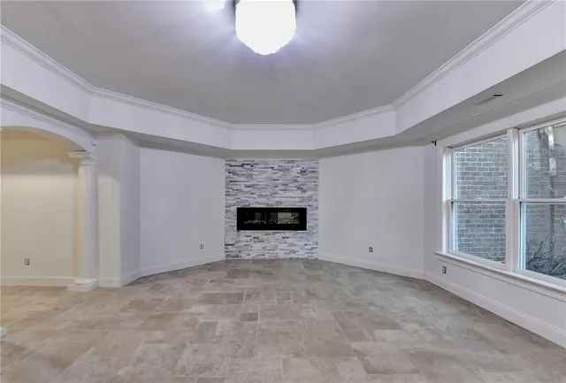 a view of an empty room with a fireplace and a window
