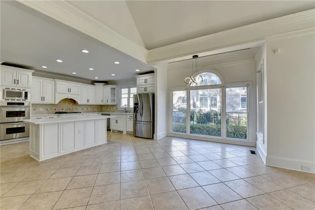 an empty room with wooden floor ceiling fan and windows