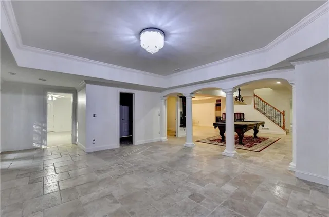 an empty room with chandelier fan and windows