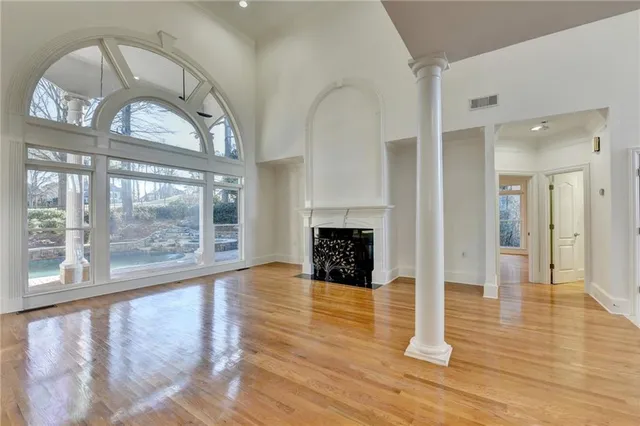a view of an empty room with a window and wooden floor