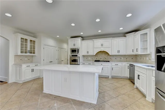 a large kitchen with stainless steel appliances kitchen island granite countertop a sink and cabinets