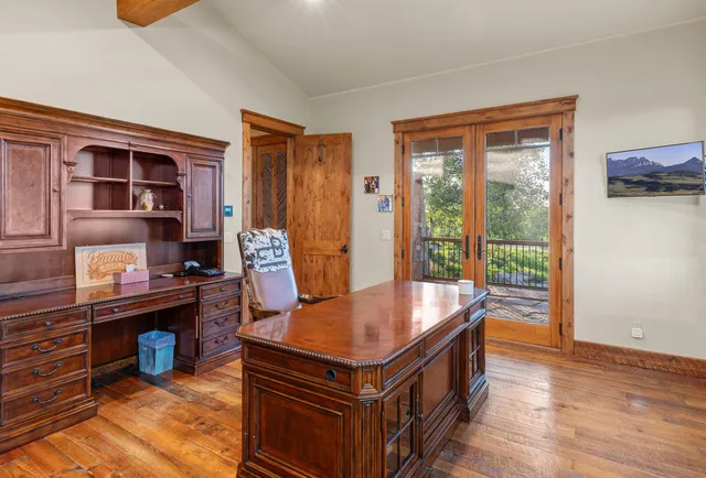 a room with kitchen island a large window wooden floor and a sink