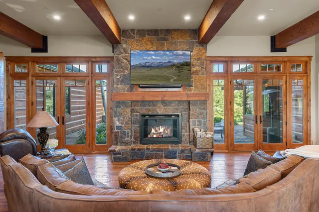 a living room with furniture fireplace and a large window