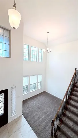 an empty room with windows and fan chandelier