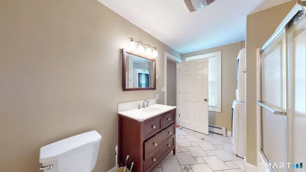 a bathroom with a toilet sink and mirror