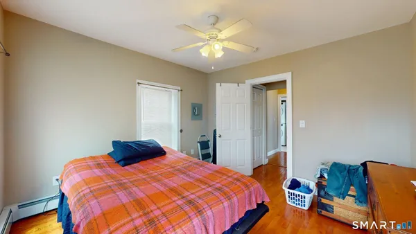 a bedroom with bed and wooden floor