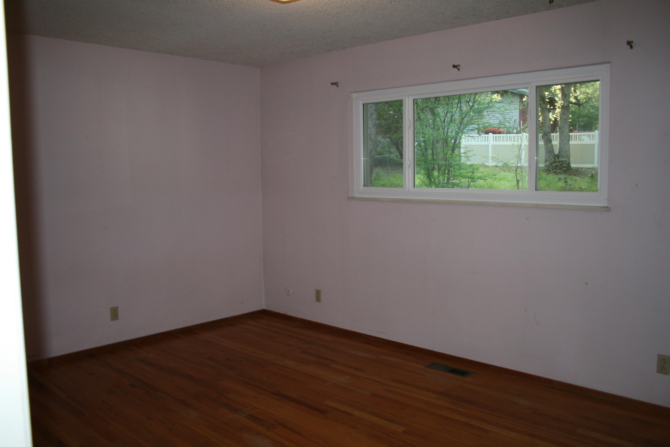 1816 Canyon Road Redding, CA 96001 - Photo 18 of 18 a view of an empty room with wooden floor and a window