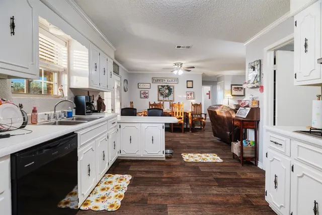 a bedroom with a bed a chandelier and a dresser