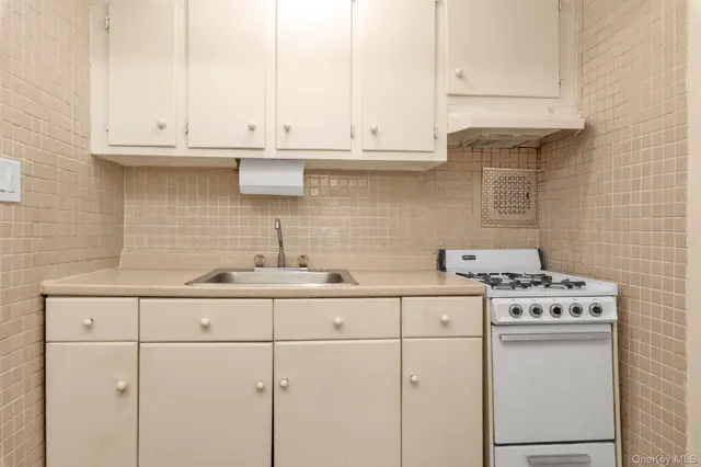 a kitchen with white cabinets and white appliances