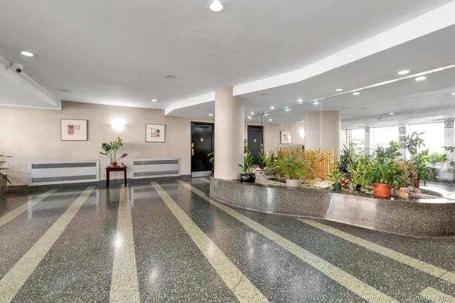 a living room with furniture and potted plants