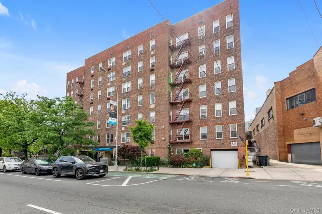 a view of a building and car parked on the side of road