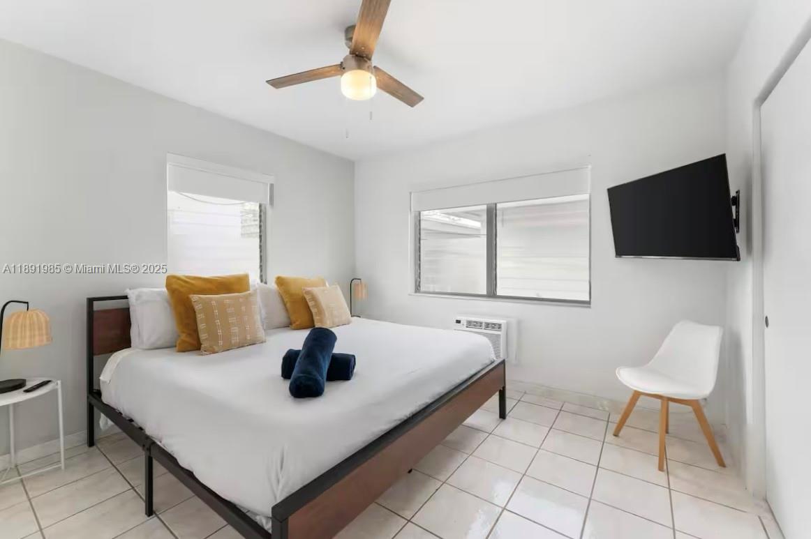7721 Harding Avenue, Unit 8 Miami Beach, FL 33141 - Photo 11 of 14 a bedroom with a bed and a flat screen tv