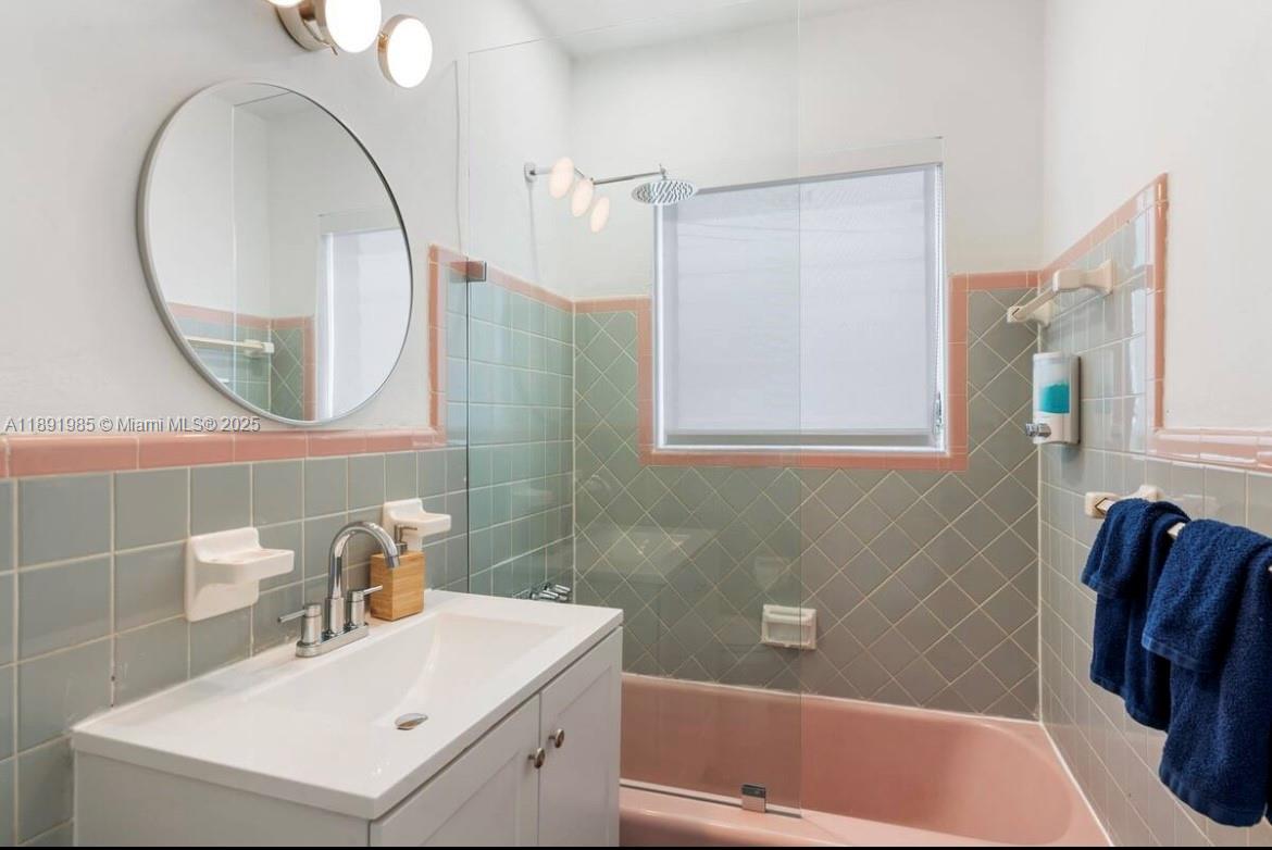 7721 Harding Avenue, Unit 8 Miami Beach, FL 33141 - Photo 14 of 14 a bathroom with a sink a bathtub and a mirror