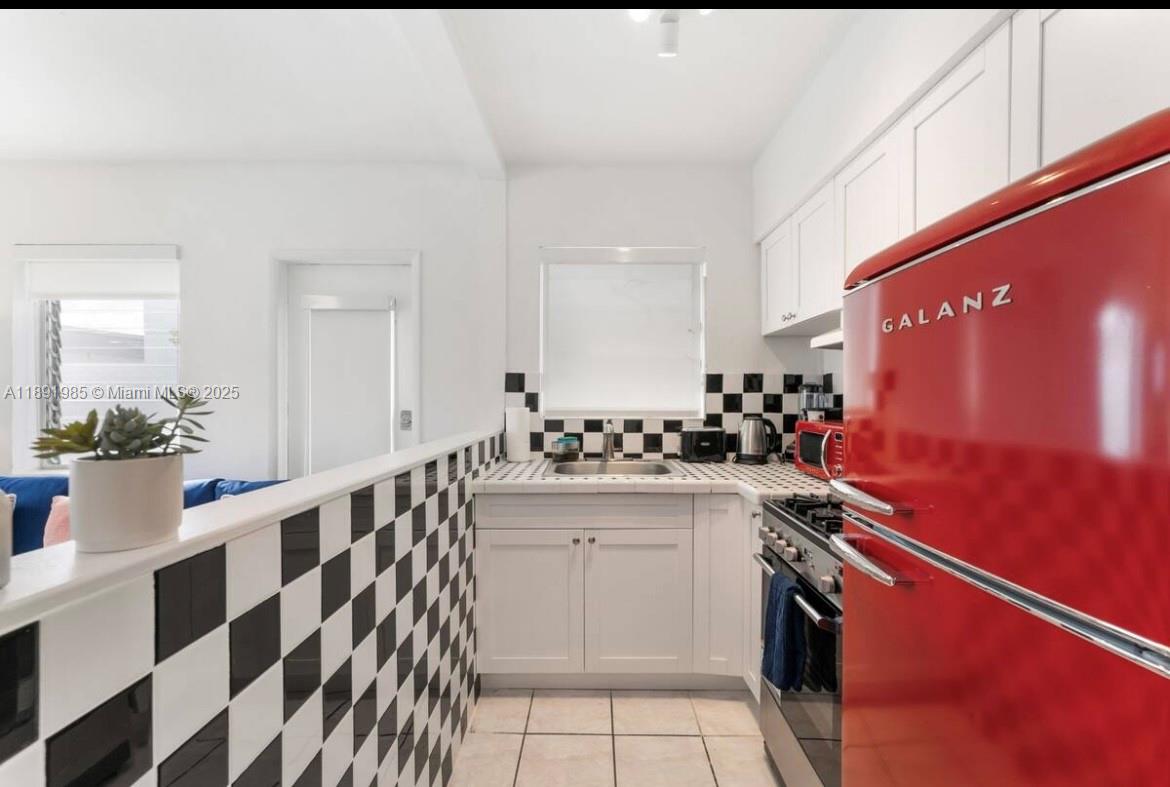 7721 Harding Avenue, Unit 8 Miami Beach, FL 33141 - Photo 6 of 14 a kitchen with granite countertop cabinets a sink and stainless steel appliances