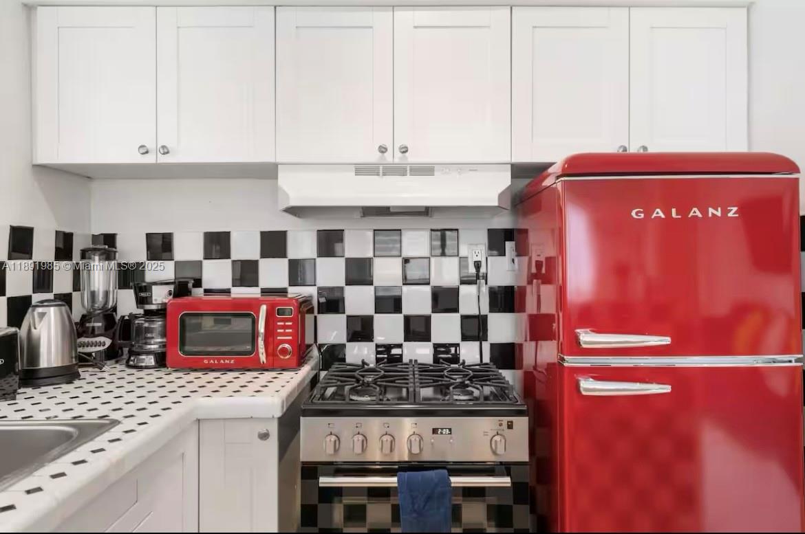 7721 Harding Avenue, Unit 8 Miami Beach, FL 33141 - Photo 7 of 14 a kitchen with a stove and a sink