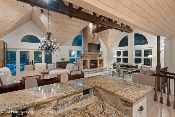 a living room with fireplace furniture and a large window