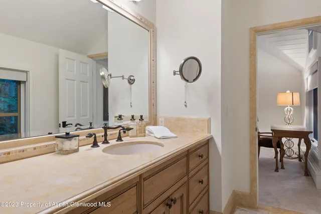 a bathroom with a granite countertop sink and a mirror
