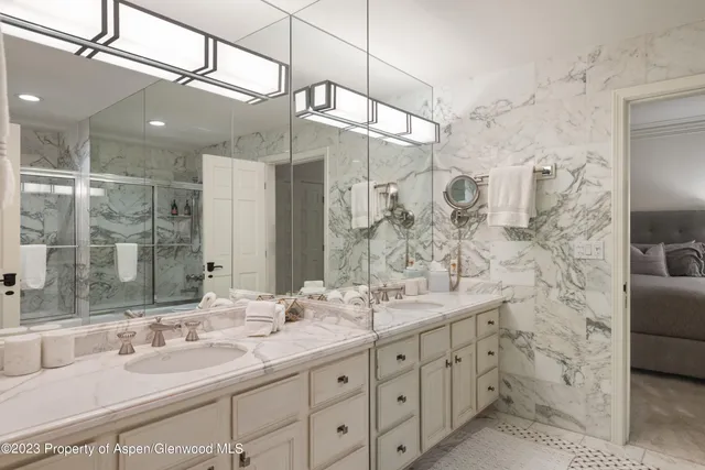 a bathroom with a double vanity sink mirror and shower