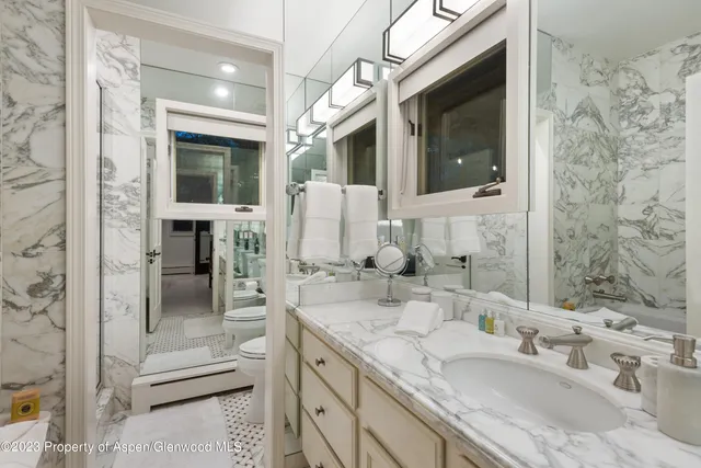 a bathroom with a granite countertop sink mirror and shower