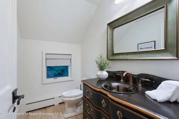 a bathroom with a toilet sink and mirror