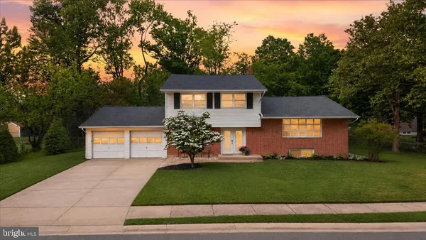 a front view of a house with a yard and trees