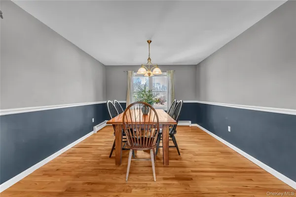 a dining room with furniture a chandelier and wooden floor
