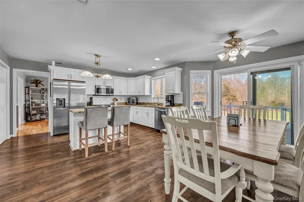 a dining room with furniture a chandelier and wooden floor
